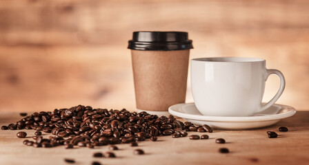 Coffee is everyones mutual best friend. Closeup shot of a paper cup and teacup surrounded by coffee beans.