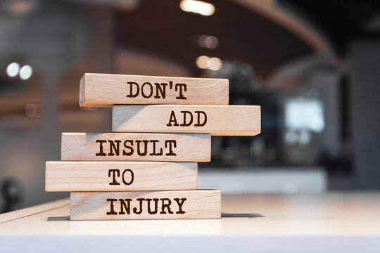Wooden blocks with words 'Don't add insult to injury'.