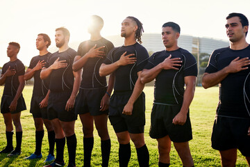 Keeping national pride. a diverse group of sportsmen standing together and singing their national anthem before playing rugby. - obrazy, fototapety, plakaty