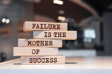 Wooden blocks with words 'Failure is the mother of success'.