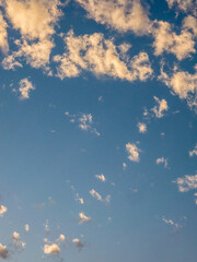 Evening clouds in an odd formation, with smaller ones appearing to fall away from the main group