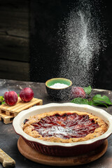 plum cake, powdered sugar is sprinkled on the cake Culinary, cooking, bakery concept. banner, menu, recipe place for text