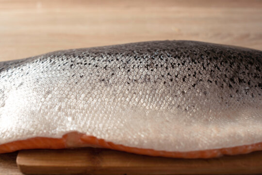 Fillet of fresh raw salmon or trout from sea fish on a cutting wooden board, top view