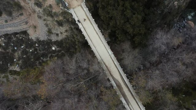 Chuck Ballard Memorial Bridge looking into Eaton Canyon Falls trail in Angeles National Forest in Pasadena, California.  Aerial pan tilt orbit.