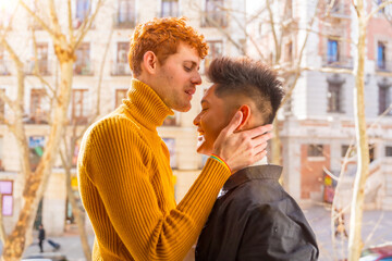 Beautiful gay couple being romantic at home on the sofa, home balcony kissing each other on the forehead, lgbt concept