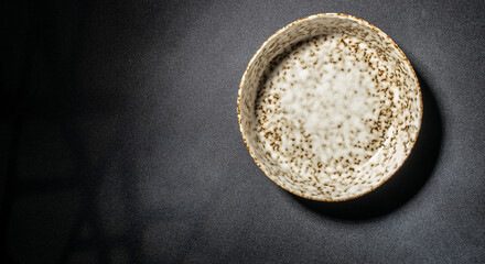 empty handmade ceramic plate on a black concrete table, Long banner format. top view