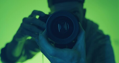 Photographer taking a photograph on a DSLR camera in the studio