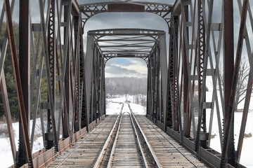 Old iron railway truss bridge built in 1893 crossing the Mississippi river in winter in Galetta,...