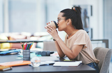 Fuelling up for another successful day. a young designer drinking coffee while working in an office.