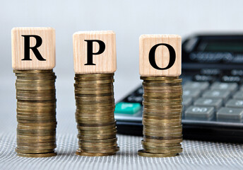 RPO - acronym on wooden cubes on the background of coins and calculator