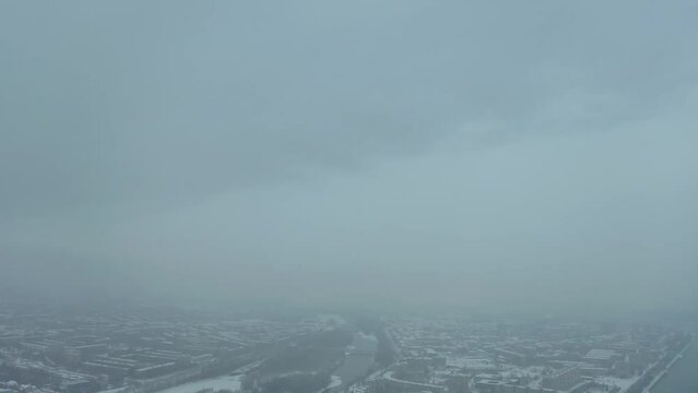 flying a drone over the central place of the city of Ust Kamenogorsk, strelka district, winter cloudy weather, city view