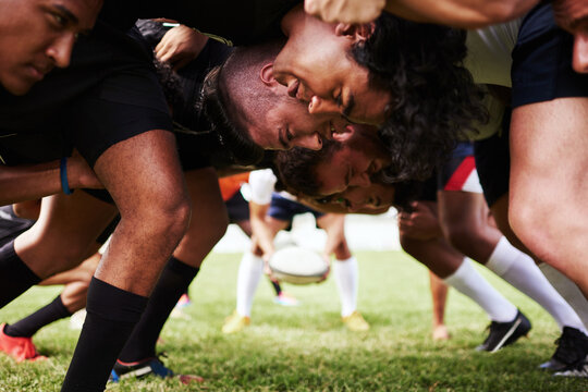 Get in, weve got a game to win. a group of young rugby players in a scrum on the field.