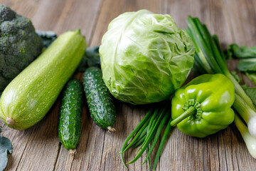 Green raw vegetables on wooden background. Healthy organic food.