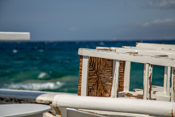 greek tavern chairs on a table with sea view 