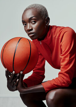 Ill outplay you any day. Studio shot of an attractive young woman playing basketball against a grey background.