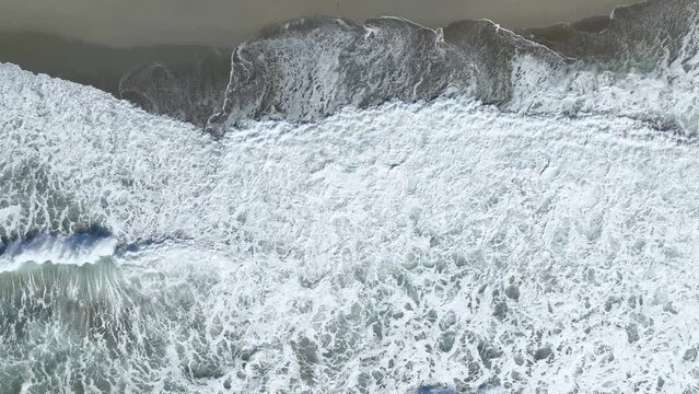 Beautiful sandy beach in a strong storm, white waves are beating on the beach, Vertical video