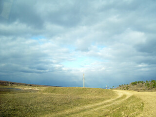 A dirt road, a reservoir and pine trees on the outskirts of the village of Vyhoda in the Odesa...