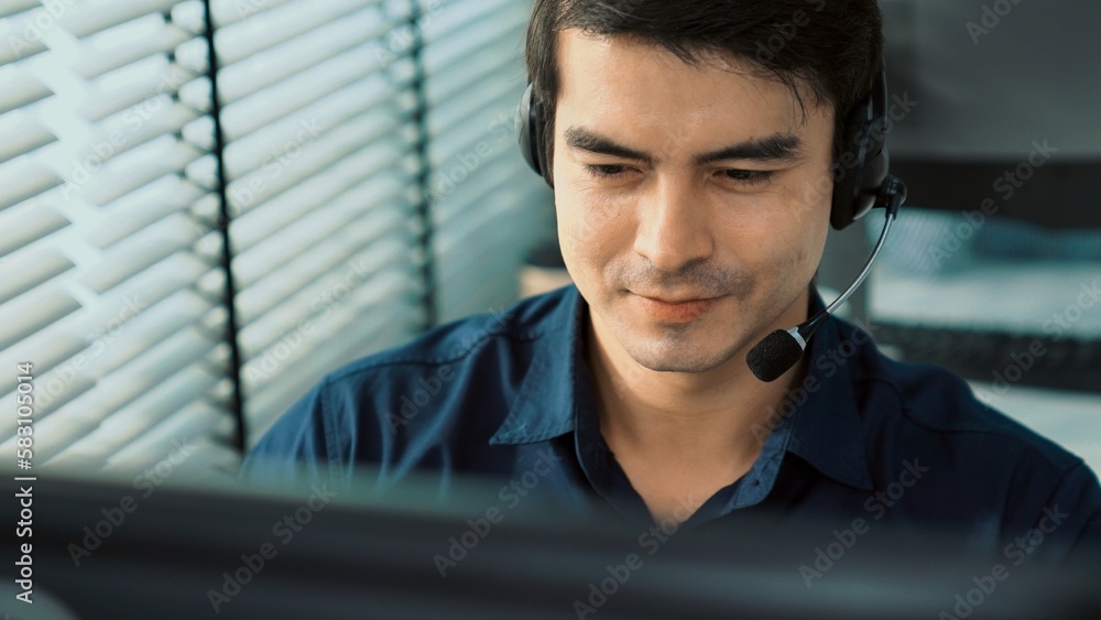 Aufkleber young competent asian male call center agent working at his computer while simultaneously speaking w