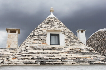 Fototapeta na wymiar Rooftop of traditional Trulli house and thunderstorm is coming, Alberobello, Puglia, Italy
