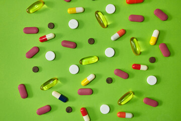 Its like an optical illusion. Studio shot of an assortment of medication against a green background.