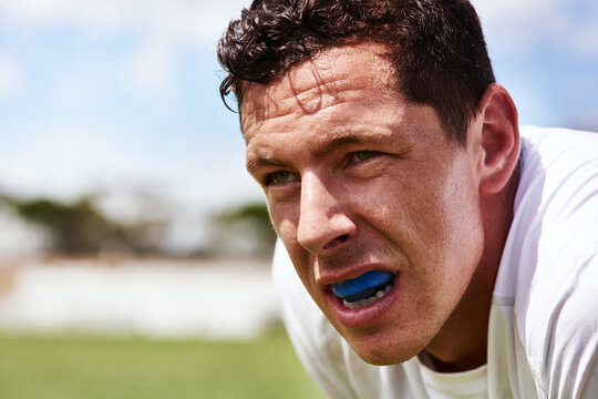Collision sport requires a bit of extra protection. a young man wearing a gum guard while playing a game of rugby.