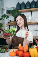 woman using laptop computer searching and learning for cooking healthy food from fresh vegetables and fruits in kitchen room.