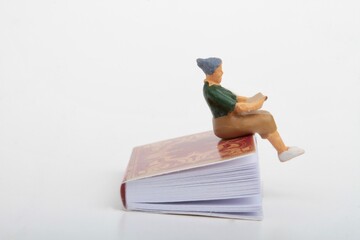 miniature people: old woman reading a book