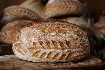 Artisan Batard Sourdough healthy Bread with leaf scoring. Open crumb high hydration Sourdough bread set on white table.