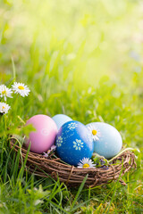 Nest with Easter eggs in grass on a sunny spring day - Easter decoration, background  -  Copy space - 583112867