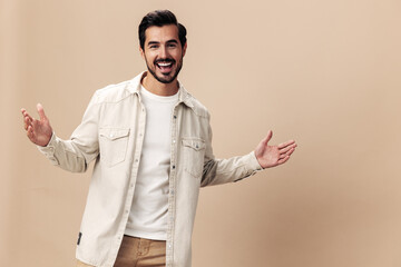 Stylish man smile on a beige background in a white t-shirt and business jacket, flying clothes hero, fashionable clothing style, copy space, space for text