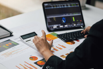 Businesswoman working with tablet analyzing investment market and calculating accounting.