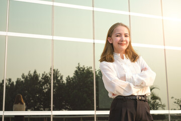 Professional business women standing crossed arms outside building city in the morning. She was smiling.