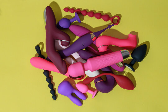 Top view of adult sex toys such as dildo, vibrator, buttplug on yellow background. Sex shop concept