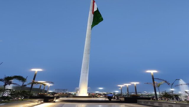 Footage of a pathway lighted in City Park Mansarovar with Indian Flag hosted in background shot at night