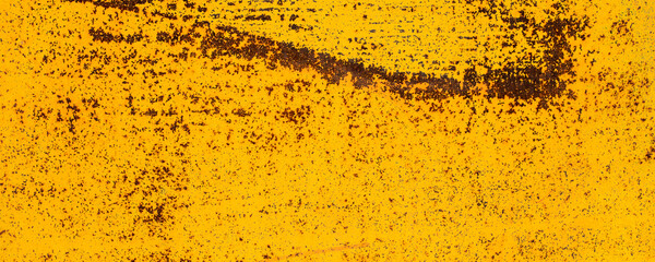 Orande rusty abstract painted metal background. Yellow texture of old plate with brown rust