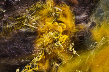 Black yellow abstract ocean background. Splashes and waves of paint under water, clouds of...