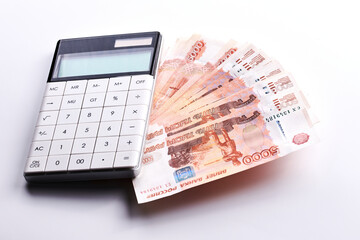 Russian rubles five thousandth banknotes, calculator and stack of money on white background