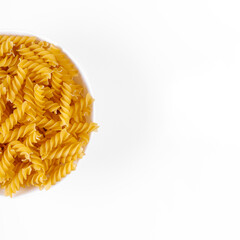 Pasta products in the form of a spiral on a plate, texture, on a white background