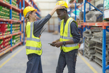 Male and female employees stand talk.