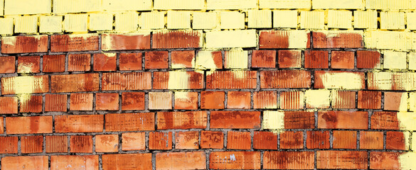 Red grunge brick wall, abstract background texture with old pattern with yellow paint on top