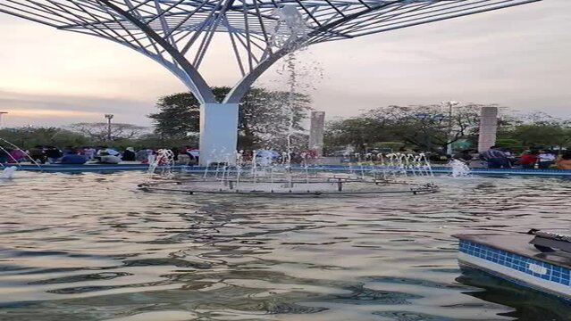 Slow motion footage of water droplets coming out of a fountain shot in City Park in Mansarovar. Footage is shot in evening during sunset against blue sky
