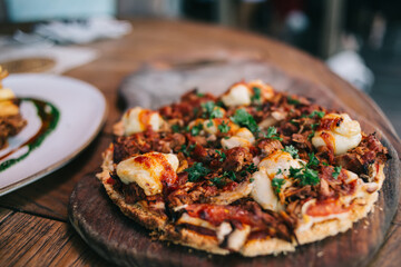 Soft focus. Top view of delicious homemade traditional mediterranean Italian pizza margarita on table, tasty vegan dish with tomatoes and basil for snacking and dinner in cafe interior