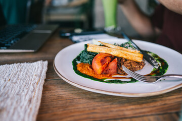 Soft focus effect.Plate with fork and tasty vegetable dish for healthy shack and nutrition on wooden table, egan tasty lunch meal with delicious ingredients and low calories on appetizer before dinner