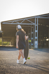 Fototapeta premium Young Woman Skateboarding in an Urban Environment