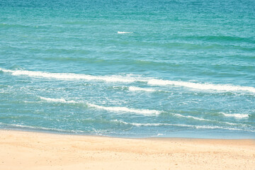 Obraz premium Transparent waves run into the sandy beach. Crystal clear water on the beach. Ecologically clean place for a carefree summer holiday.