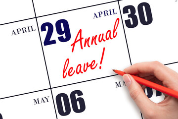 Hand writing the text ANNUAL LEAVE and drawing the sun on the calendar date April 29