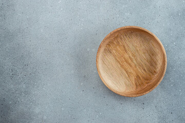 wooden bowl on a gray background. utensils for the kitchen, bowls, plates on a gray background. Texture of wood