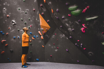 Male Rock Climber looking up at a climbing wall