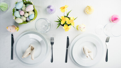 Easter table setting with colored eggs and flowers