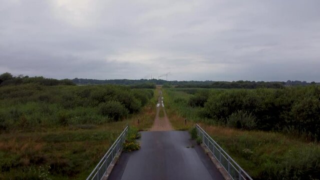 Aerial of a bridge and a road surrounded by water ponds and swamps in Romo Denmark